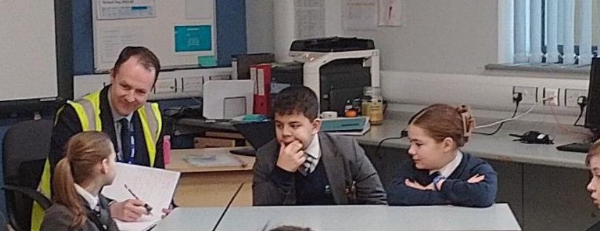 Students from The Birley Academy sitting around a table talking with Mr Casey and sharing their ideas at the Education Council meeting